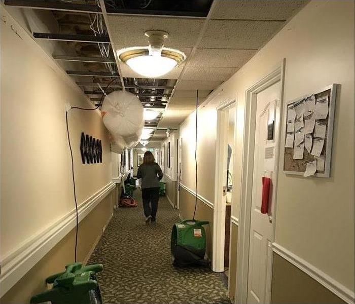 The ceiling of a commercial facility has been damaged with water due to a broken pipe. Drying equipment has been placed