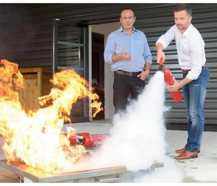 People putting out a fire with an fire extinguisher.